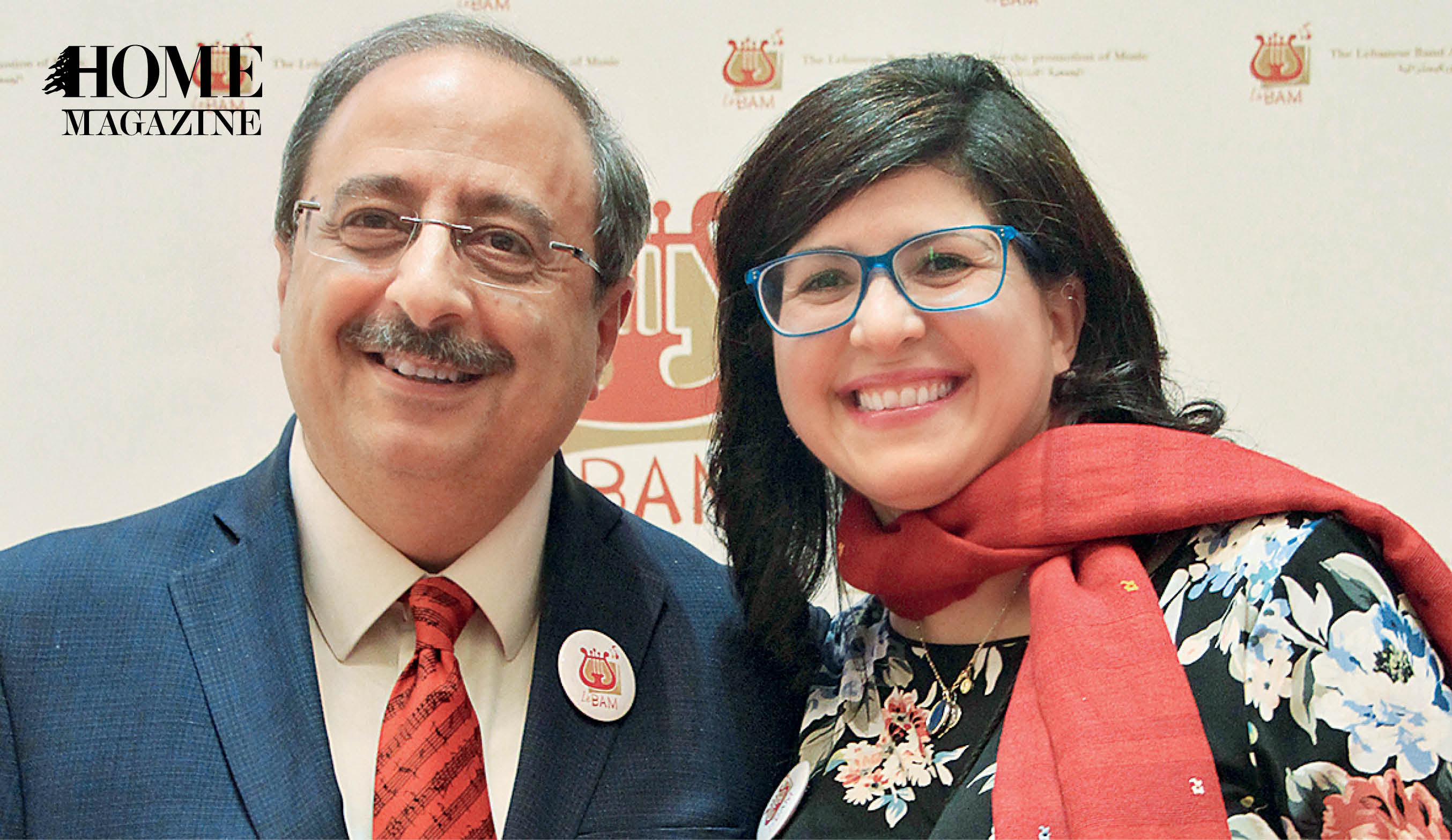Bald smiling man and smiling woman with black hear both wearing eyeglasses