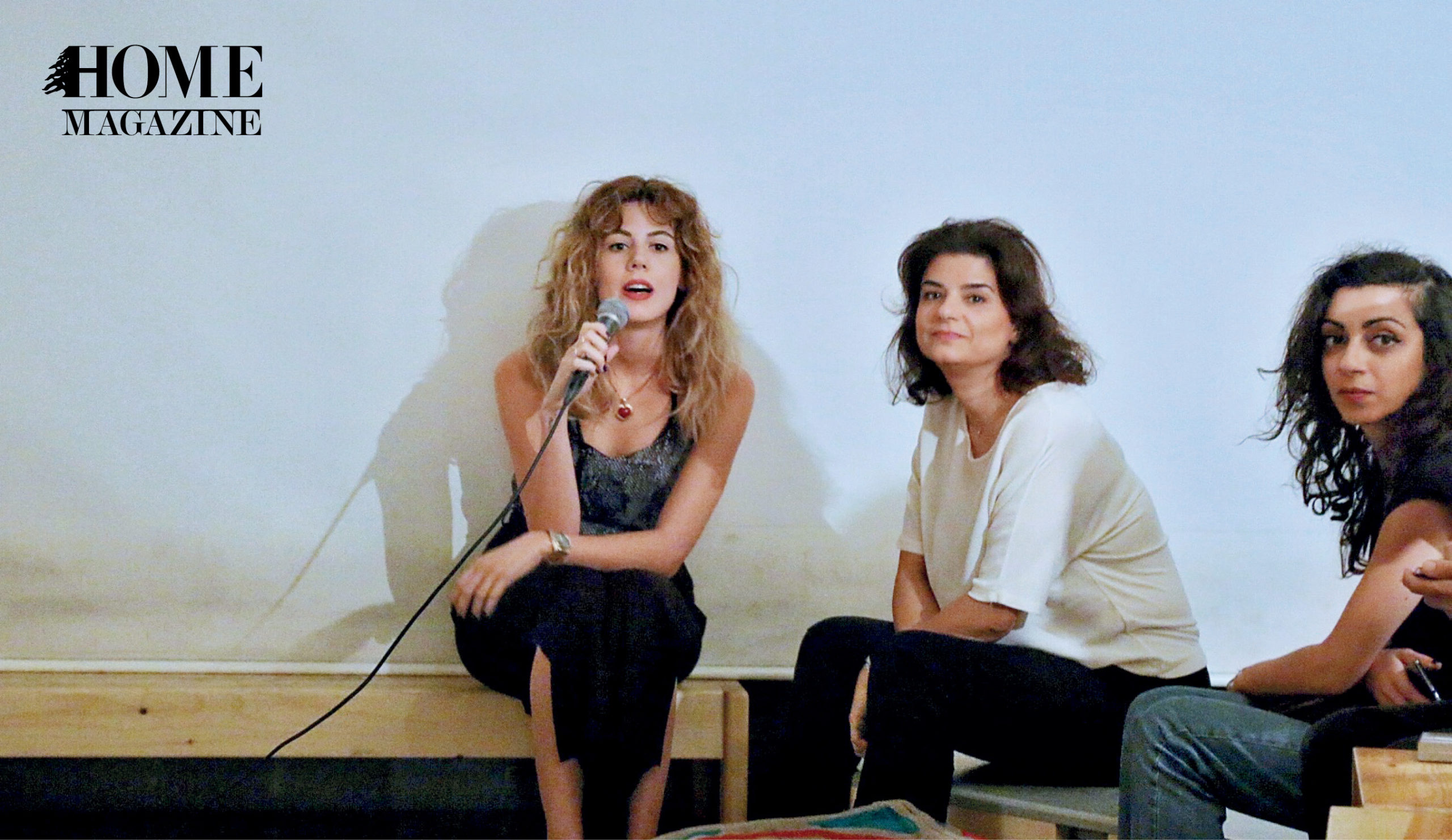 Three girls with one of them speaking on a microphone
