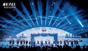 Group of people performing on a stage with blue lighting