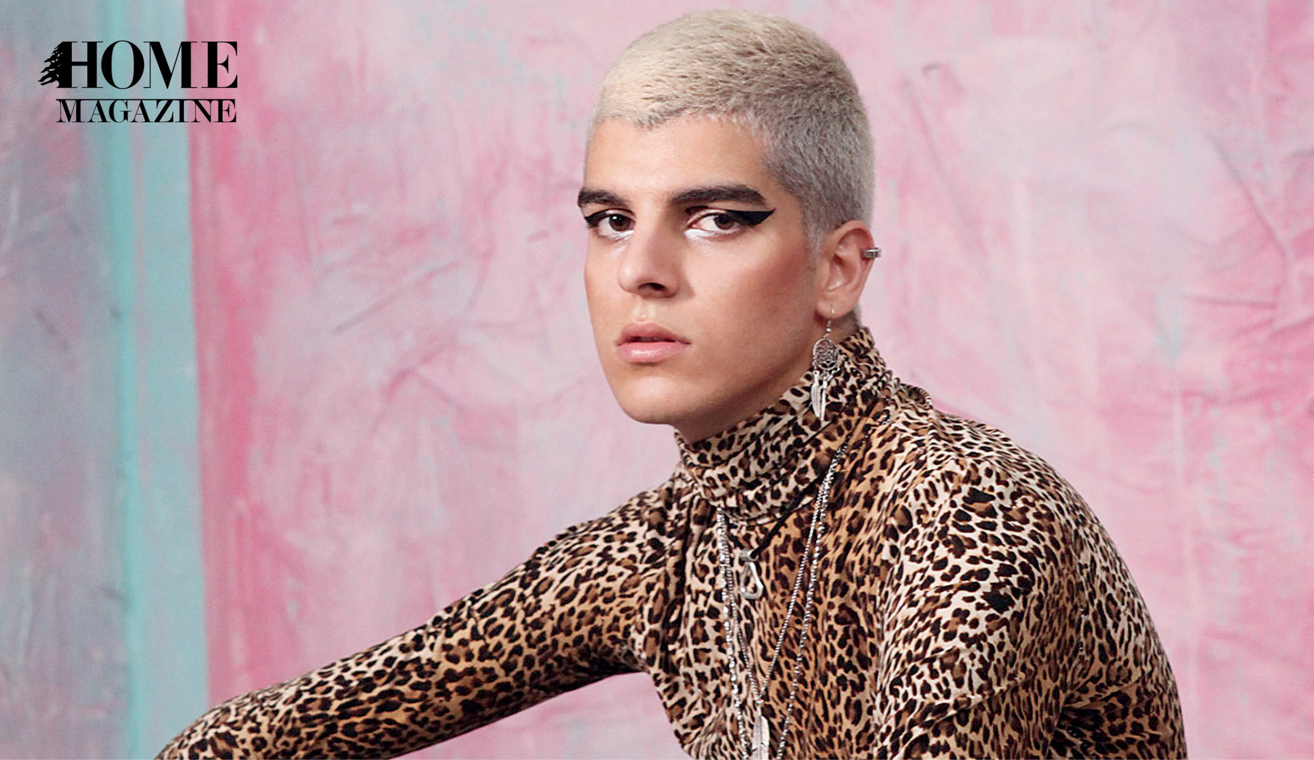 A man with blond hair and make up wearing a tiger printed shirt